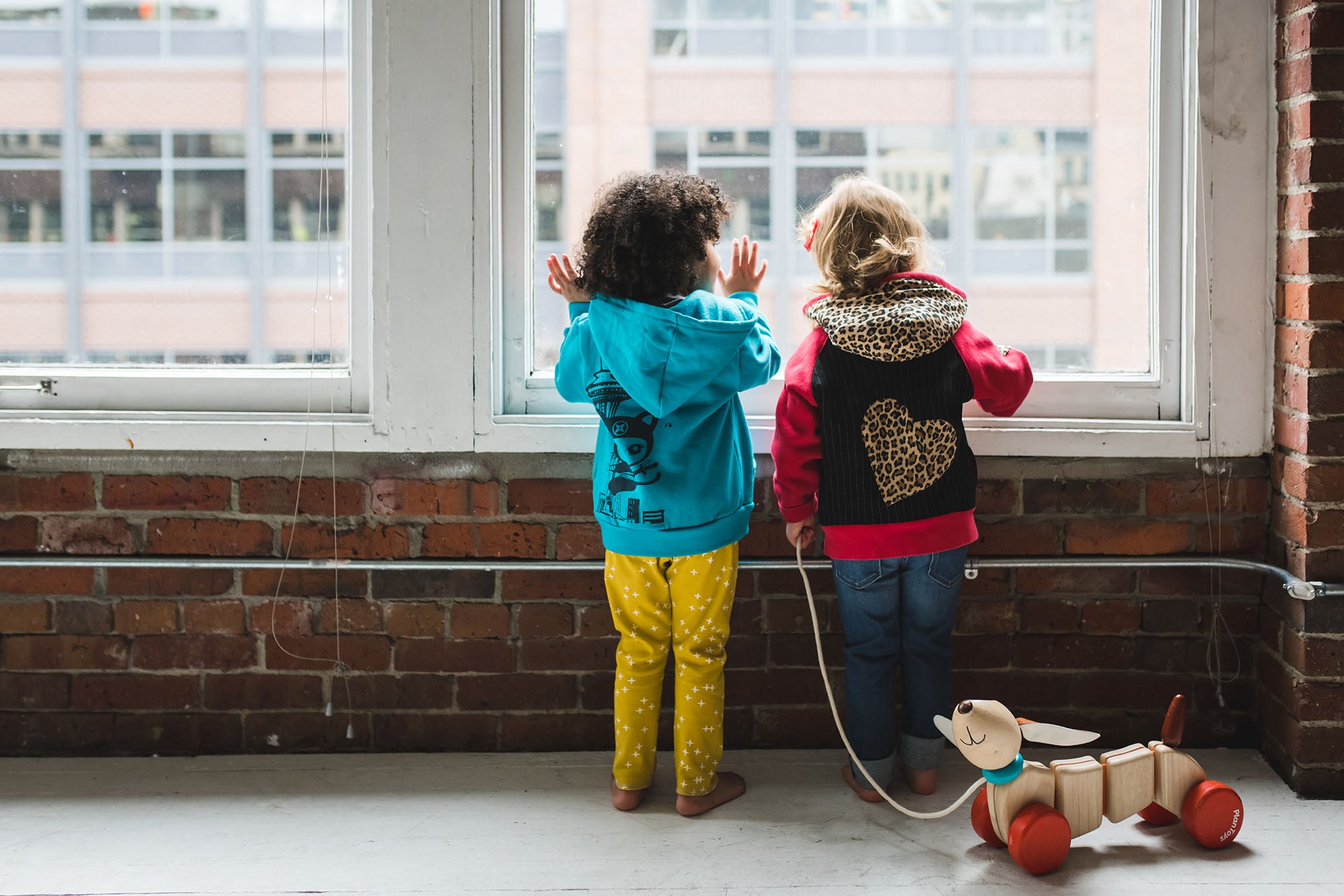 Children at the Window with a toy puppy at their feet The clothing is styled by Bootyland Kids