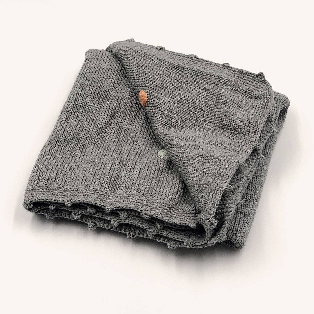 Folded gray knit blanket on a white background