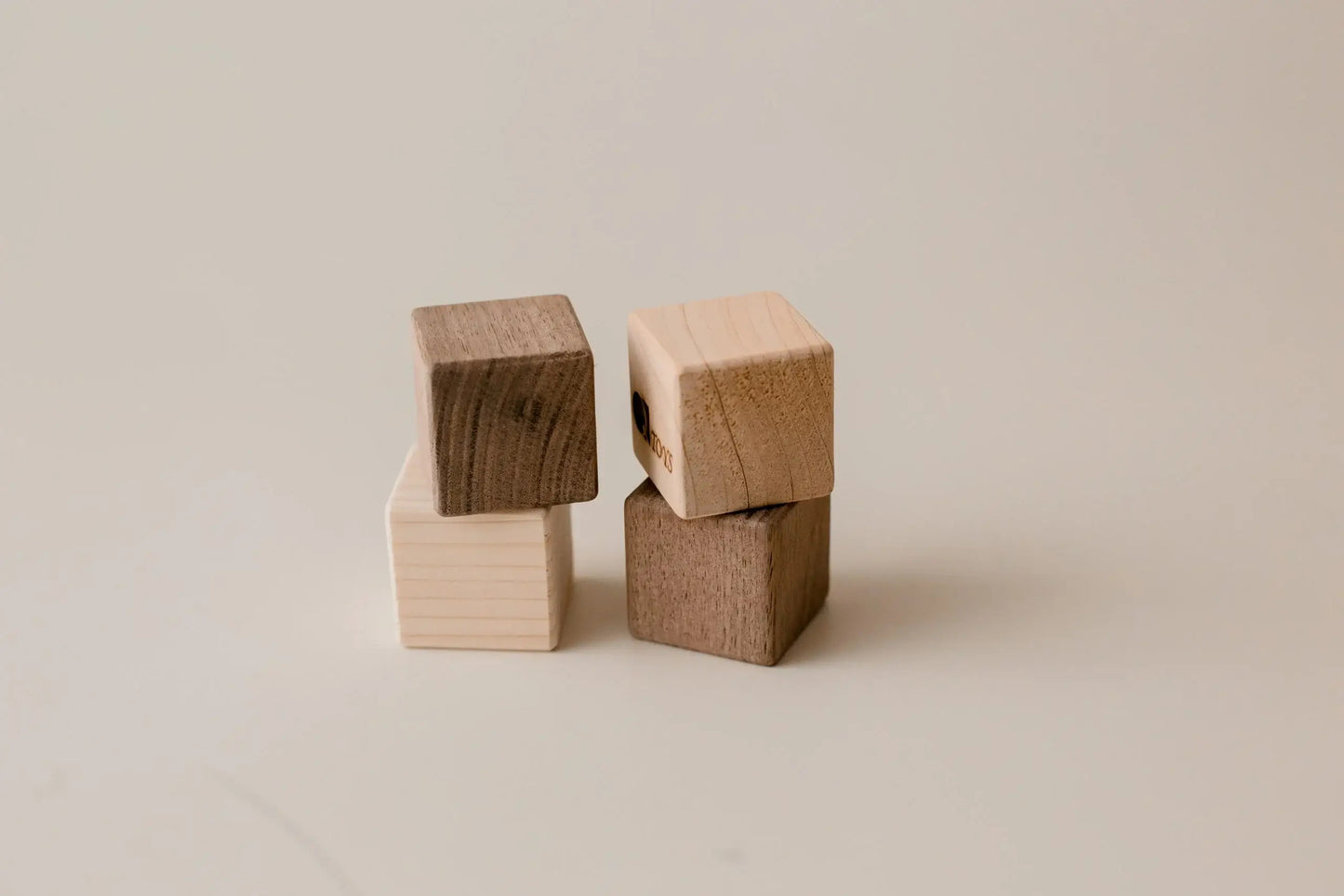 Four wooden blocks stacked on a beige background