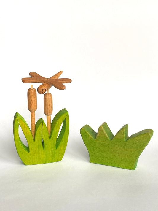 Wooden dragonfly and reeds on a white background