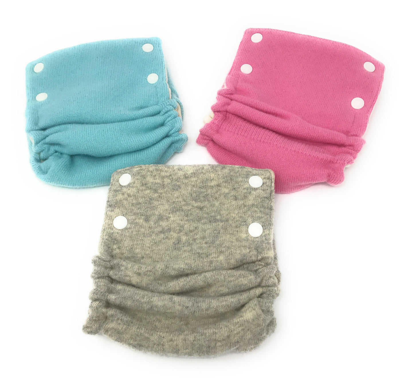 Three cloth diapers in teal, pink, and gray on a white background