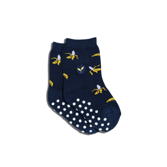 Navy blue socks with banana pattern and white polka dots on a white background