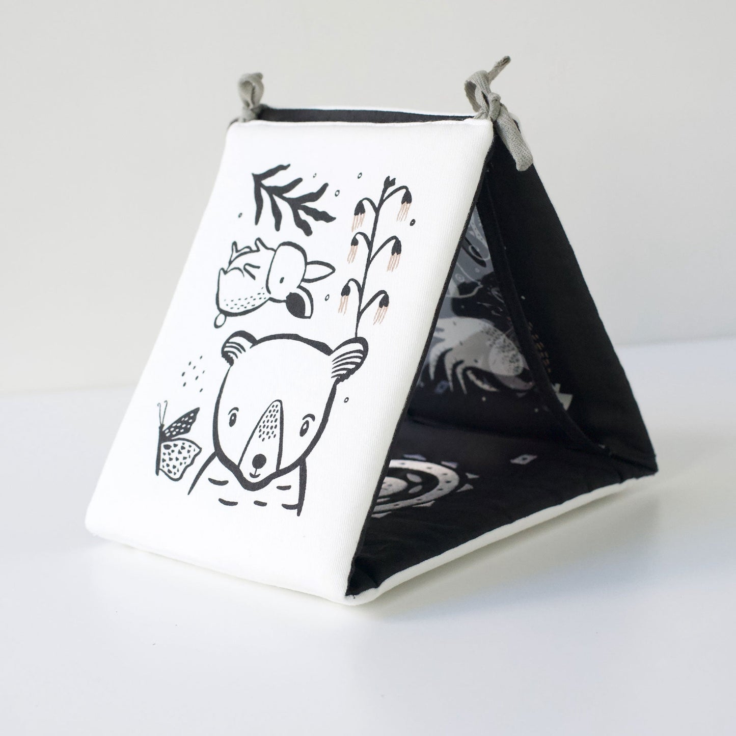 Fabric pyramid with black and white designs on a white background