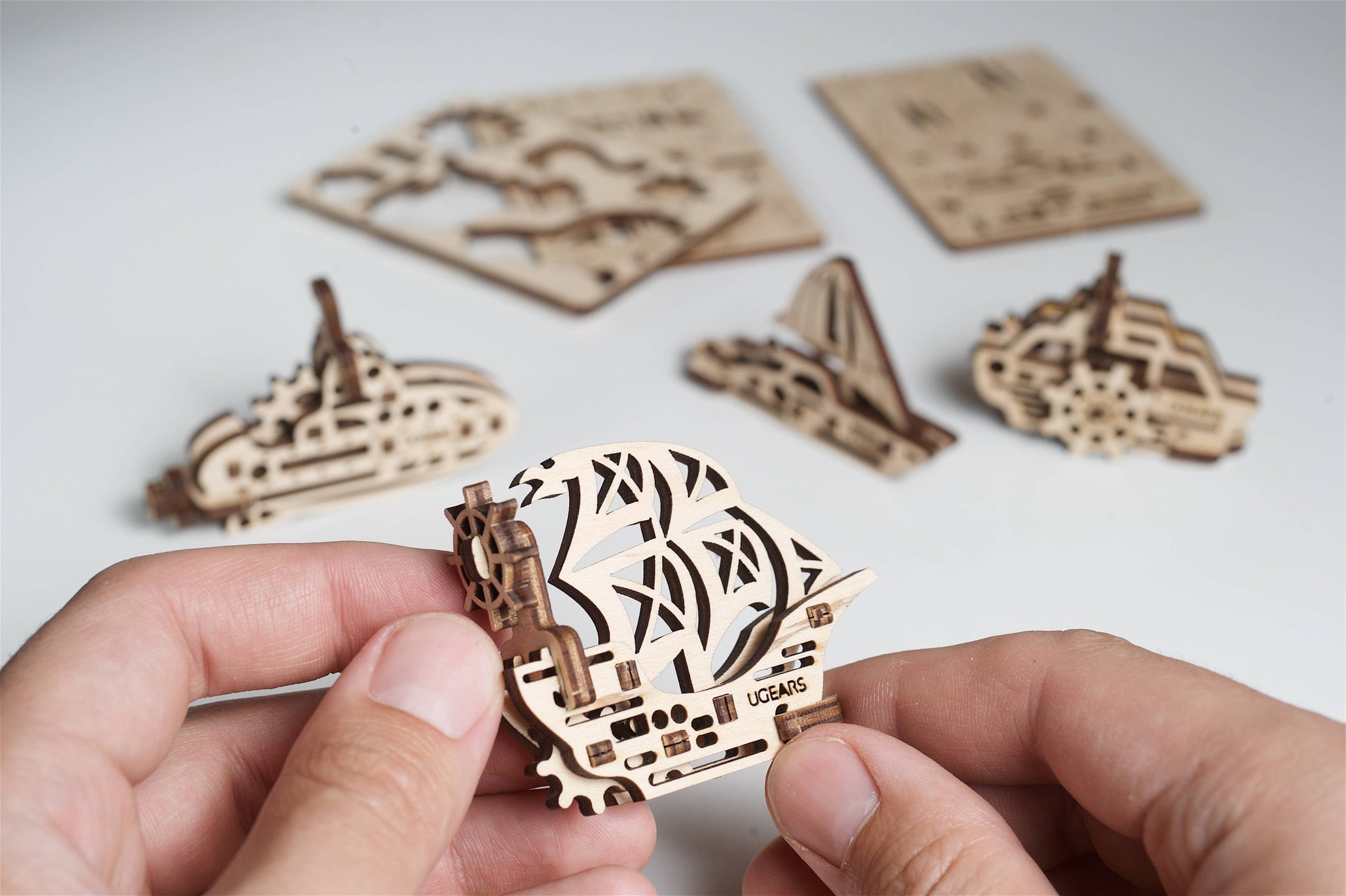 3D wooden puzzles with intricate design held by hands on a light background