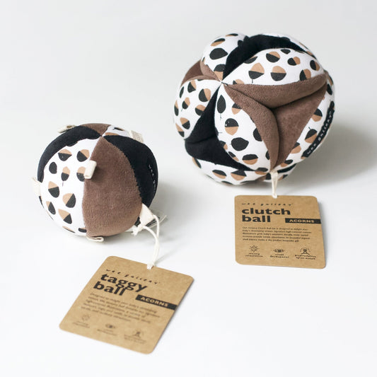 Two fabric clutch balls with patterned design and tags on a white background