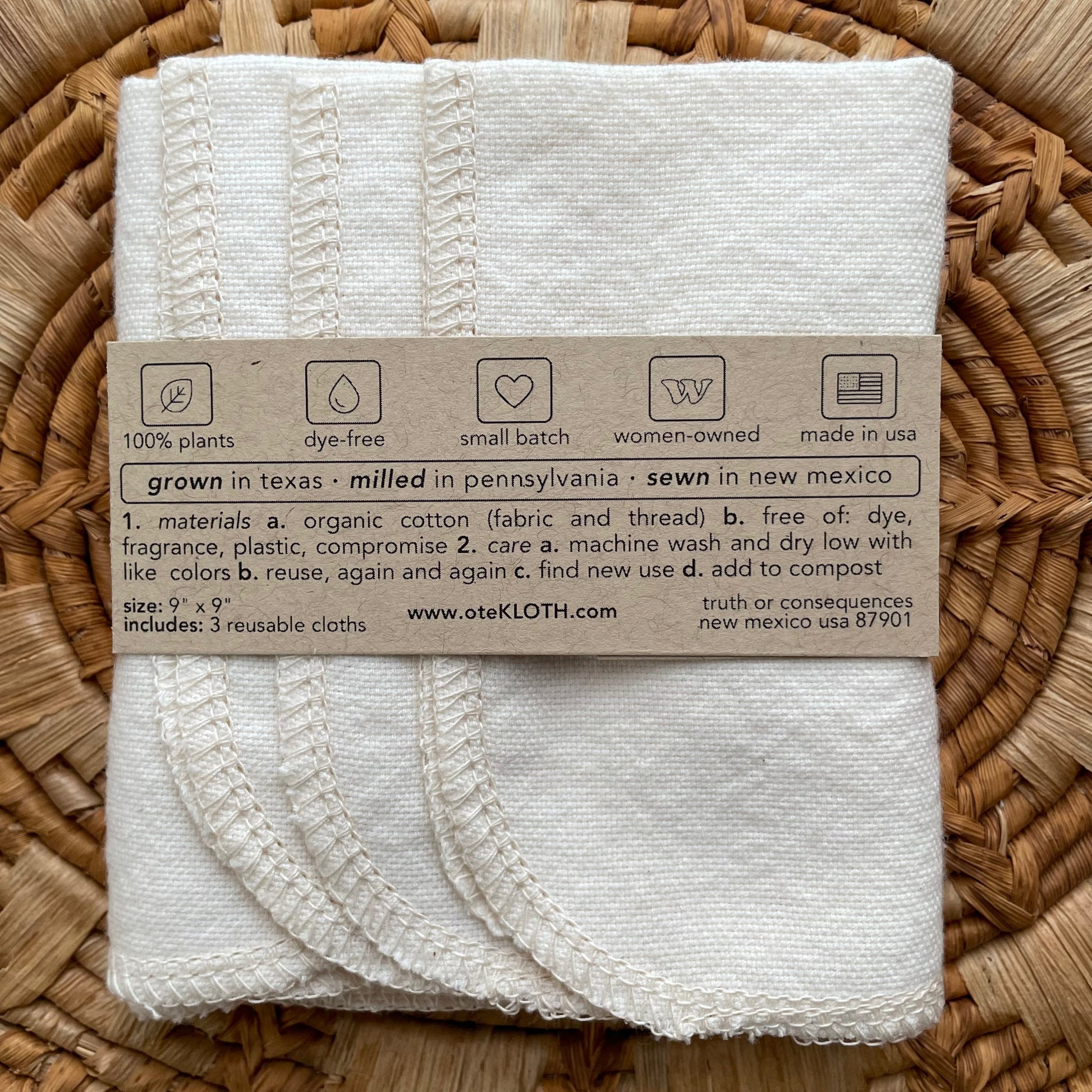 Folded white cloth with a label on a woven surface