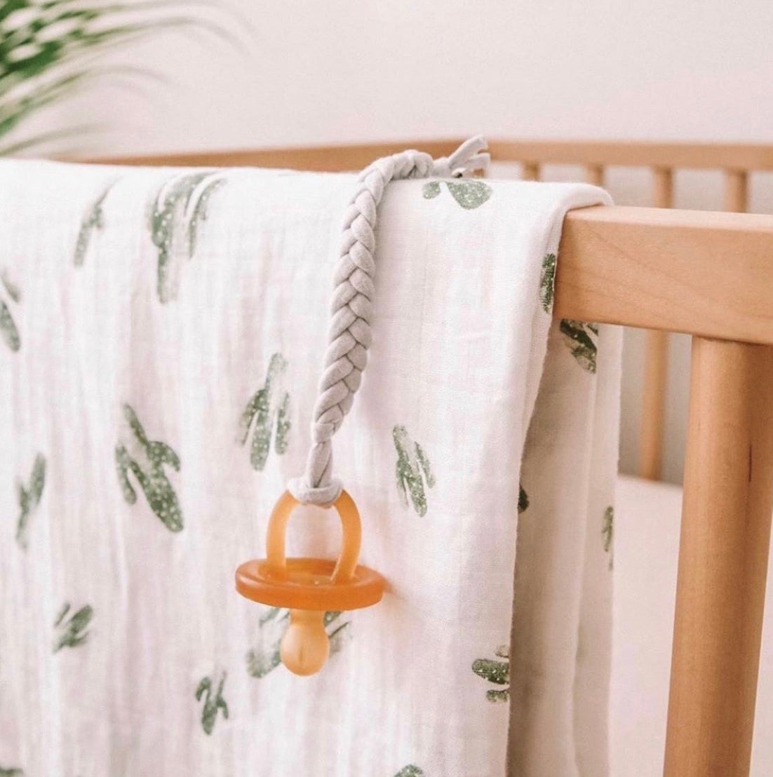 Natural Rubber Round Pacifier hanging over a crib