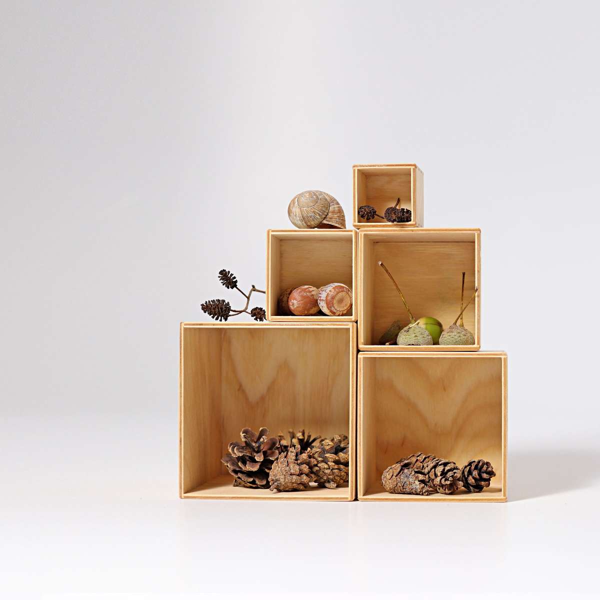 natural nesting boxes stacked and filled with acorns, acorn caps, and pinecones